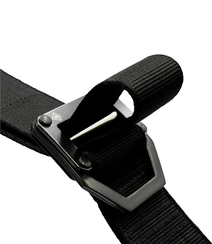 Close-up of a black webbed strap  going through the black metal quick-release buckle on a plain white background |color_black
